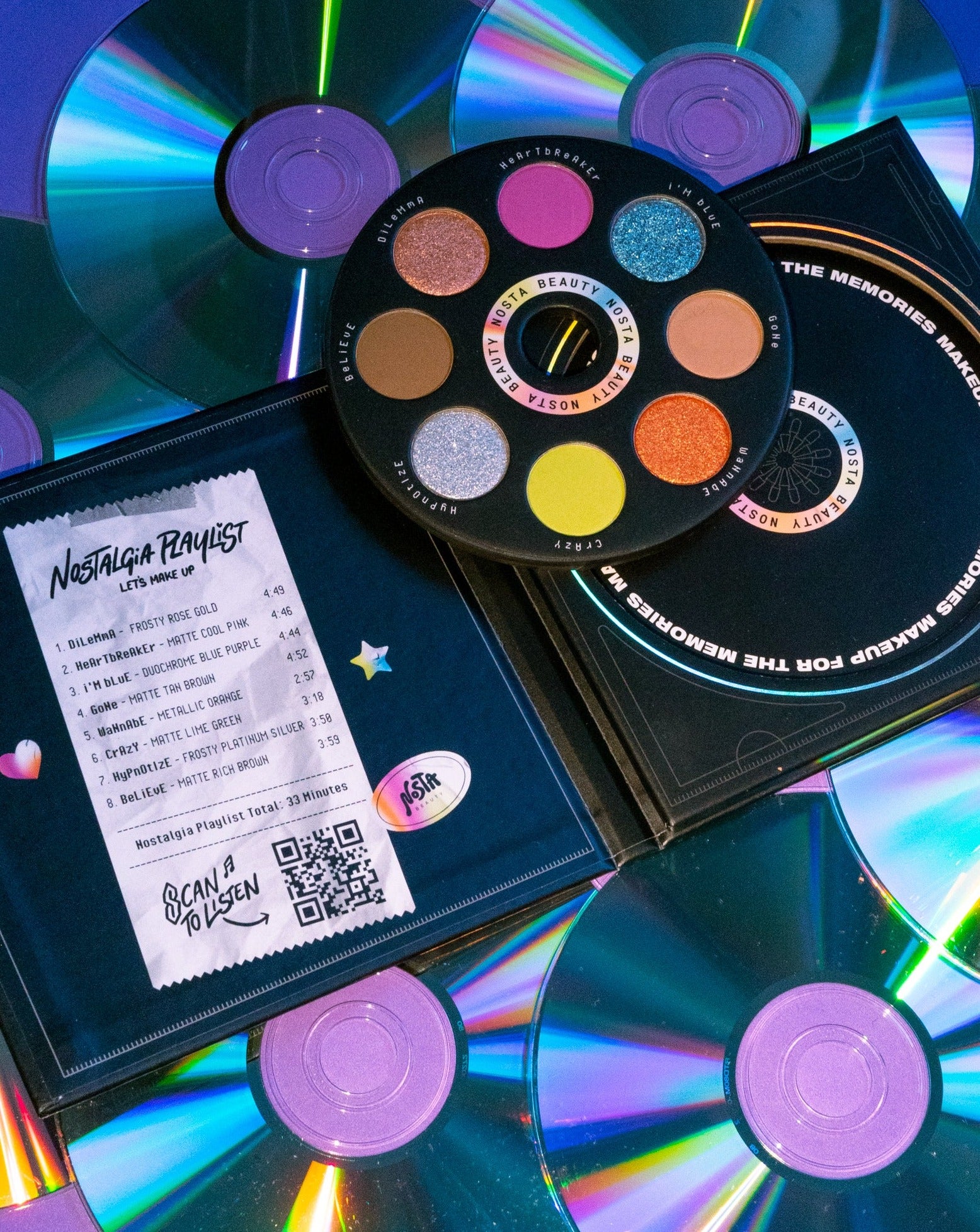Adorably packaged CD case eyeshadow palette with 8 nostalgic hit songs from the 90s & 2000s listed on left as inspiration for shades.